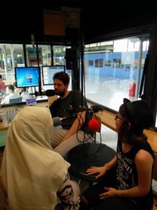 Zwei Teilnehmerinnen gemeinsam mit einem Masterstudenten im Radiostudio von HORADS 88,6 an der HdM.
